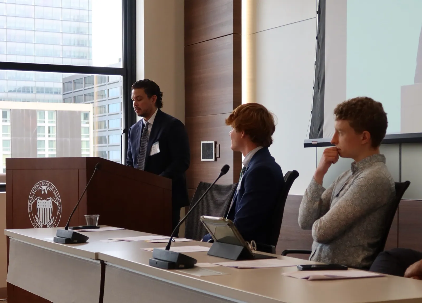 Tyler Sotomayor speaking at the lectern as a discussant at the Federal Reserve Bank of Cleveland