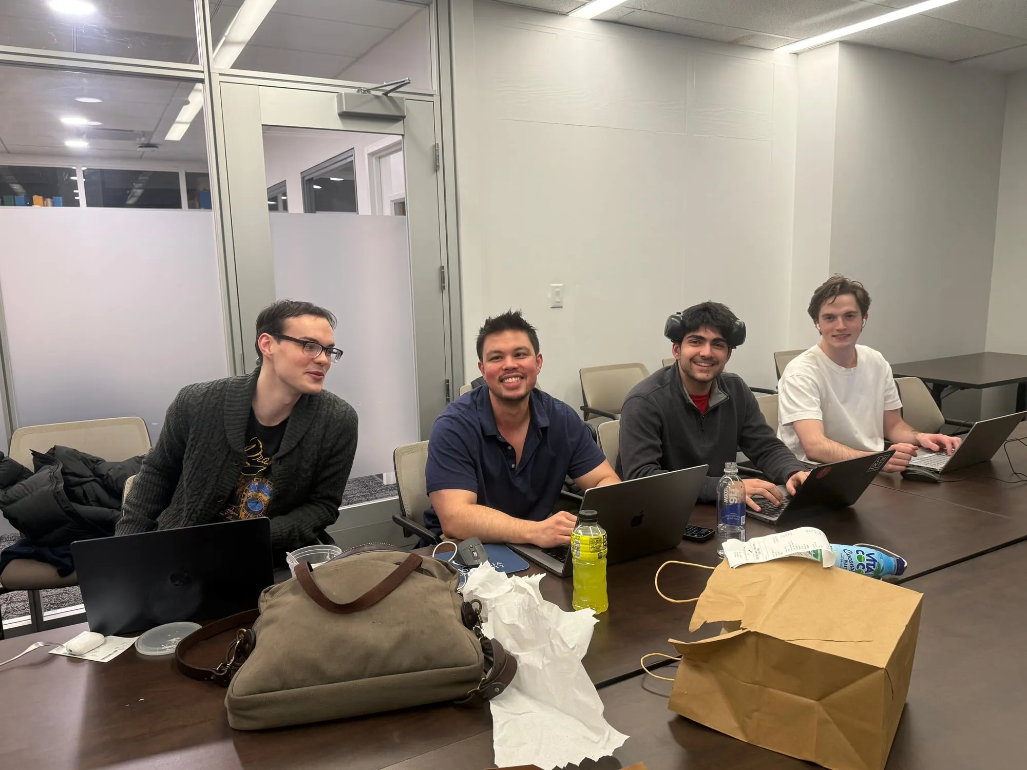 Tyler Sotomayor and three teammates working at laptops late in the evening during the Econometrics Game